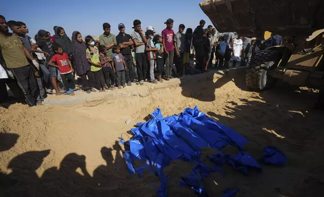 People bury the bodies of Palestinians taken by the Israeli military during operations in Gaza and returned this week, in Khan Younis, Gaza Strip, Thursday, Sept. 26, 2024. (AP Photo/Abdel Kareem Hana)