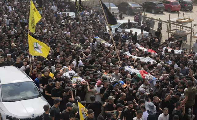 Mourners carry the bodies of Palestinian men who were killed during an Israeli military operation, some draped in the Palestinian and the Islamic Jihad militant group flags, during their funeral in Jenin, West Bank, Friday, Sept. 6, 2024. (AP Photo/Nasser Nasser)