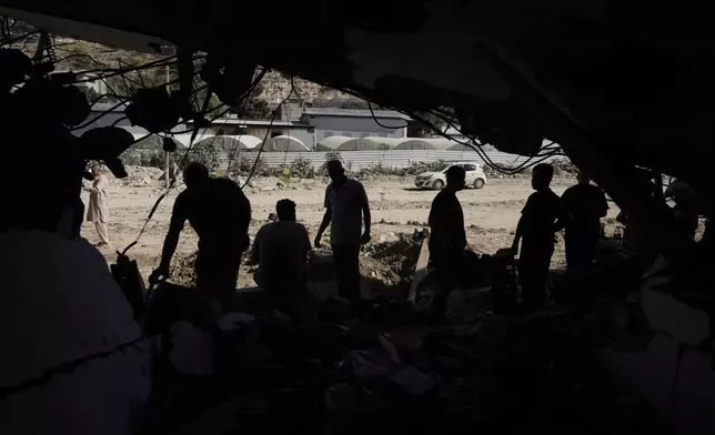 People inspect the destruction following an Israeli forces raid in Tulkarem, West Bank, on Wednesday, Sept. 11, 2024. (AP Photo/Majdi Mohammed)