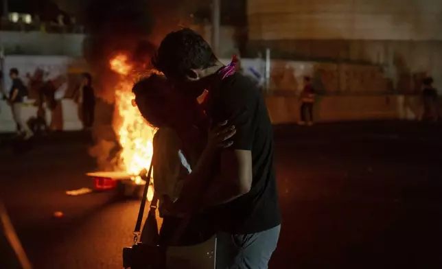 Two people kiss during a protest calling for a deal for the immediate release of hostages held in the Gaza Strip by Hamas, in Tel Aviv, Israel, Sunday, Sept. 1, 2024. (AP Photo/Ohad Zwigenberg)