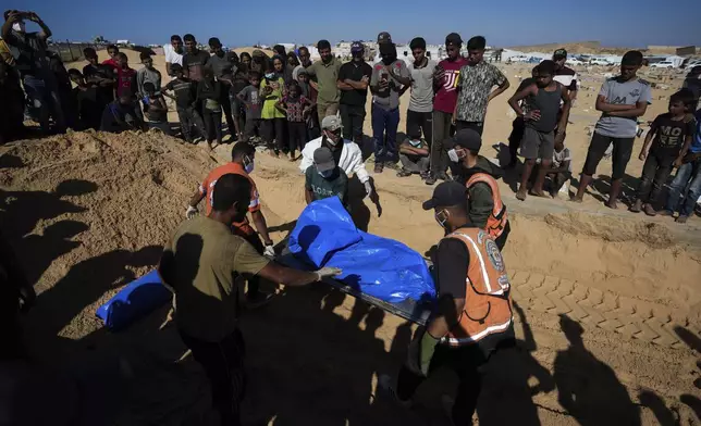 People bury the bodies of Palestinians taken by the Israeli military during operations in Gaza and returned this week, in Khan Younis, Gaza Strip, Thursday, Sept. 26, 2024. (AP Photo/Abdel Kareem Hana)