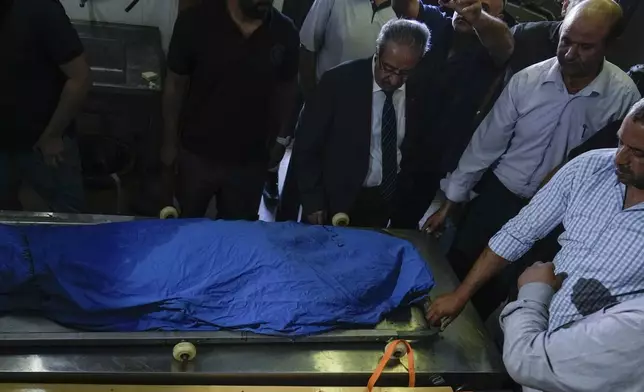 Palestinians look at the body of Turkish-American Aysenur Ezgi Eygi at the hospital morgue in Nablus, West Bank, Saturday, Sept. 7, 2024. Ezgi Eygi, 26, died after being shot in the head on Friday, Palestinian doctors said. Witnesses to the shooting said the was fatally shot by Israeli forces in a moment of calm after clashes between Palestinians and Israeli forces in the northern West Bank. (AP Photo/Majdi Mohammed)