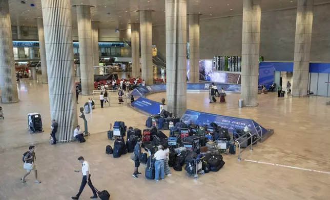 Travelers are seen at Ben Gurion International Airport near Tel Aviv, Israel, Monday Sept. 2, 2024. Outgoing flights at the airport were halted for two hours on Monday morning as part of a general strike launched in response to the deaths of hostages held in Gaza. (AP Photo/Ohad Zwigenberg)