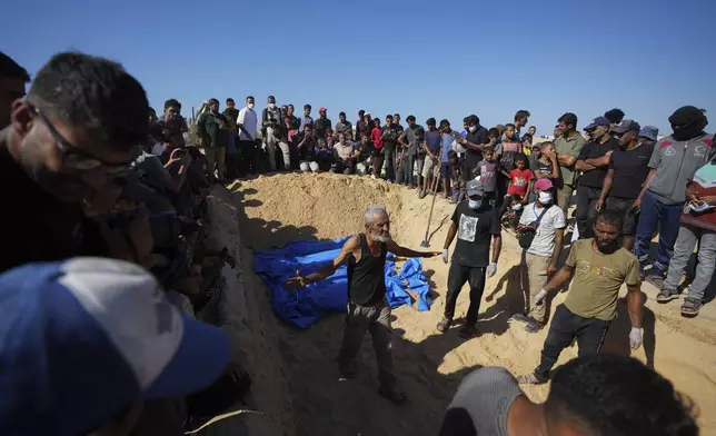 People bury the bodies of Palestinians taken by the Israeli military during operations in Gaza and returned this week, in Khan Younis, Gaza Strip, Thursday, Sept. 26, 2024. (AP Photo/Abdel Kareem Hana)