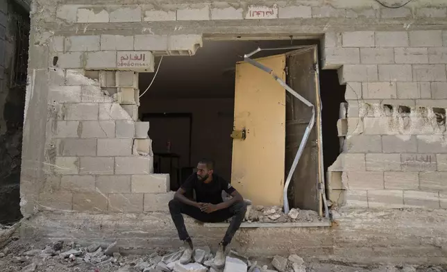 A Palestinian refugee sits by his partly destroyed house that was damaged during the Israeli army operation in the West Bank refugee camp of Tulkarem, in Tulkarem, Thursday, Sept. 5, 2024. (AP Photo/Nasser Nasser)