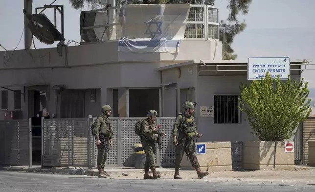 Israeli soldiers stand guard near the site of a deadly shooting attack where Israeli officials say three people were shot and killed at the Allenby Bridge Crossing between the West Bank and Jordan, Sunday, Sept. 8, 2024. (AP Photo/Mahmoud Illean)