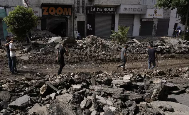 Palestinian walk on a street damaged during a military operation in the West Bank city of Jenin, Sunday, Sept. 1, 2024. (AP Photo/Majdi Mohammed)