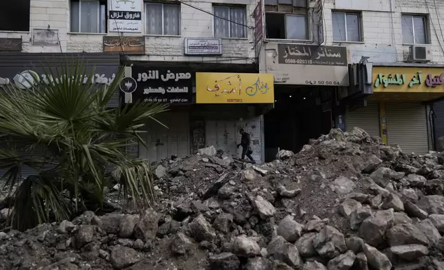 A Palestinian walks on a damaged street during a military operation in the West Bank city of Jenin, Sunday, Sept. 1, 2024. (AP Photo/Majdi Mohammed)