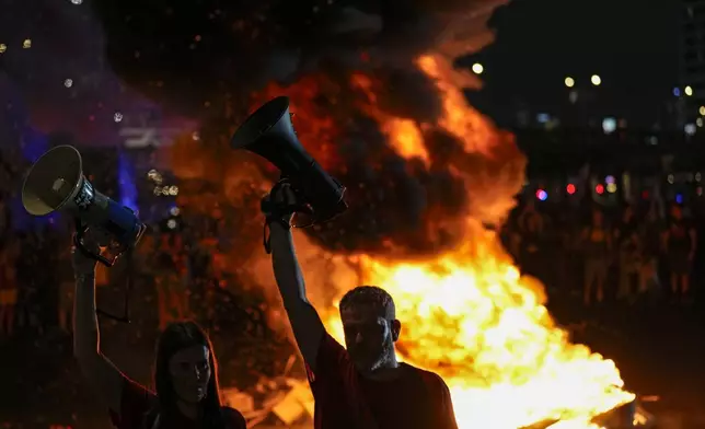 People block a road as they protest calling for a deal for immediate release of hostages held in the Gaza Strip by the Hamas militant group, in Tel Aviv, Sunday, Sept. 1, 2024. (AP Photo/Ariel Schalit)