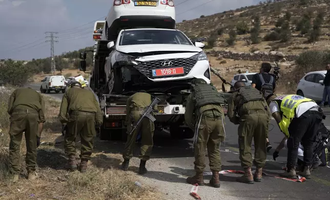 Israeli security forces and rescue services check the scene of a shooting attack in the West Bank city of Tarkumiya, Sunday, Sept. 1, 2024. Israeli authorities said Palestinian gunmen killed a few Israelis in a shooting attack in the occupied West Bank. Israel has been carrying out large-scale military raids in the territory in recent days. (AP Photo/Mahmoud Illean)