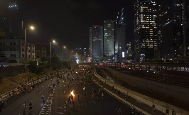 People block a road as they protest, calling for a deal for the immediate release of hostages held in the Gaza Strip by Hamas, in Tel Aviv, Israel, Sunday, Sept. 1, 2024. (AP Photo/Ohad Zwigenberg)