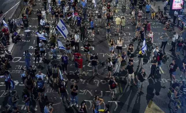 People protest against Prime Minister Benjamin Netanyahu's government and call for the release of hostages held in the Gaza Strip by the Hamas militant group, in Tel Aviv, Israel, Saturday, Aug. 31, 2024. (AP Photo/Ohad Zwigenberg)