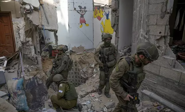 Israeli soldiers stand at the entrance of a tunnel where the military says six Israeli hostages were recently killed by Hamas militants, in the southern Gaza Strip on Friday, Sept. 13, 2024. (AP Photo/Leo Correa)