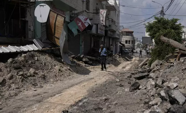 A Palestinian walks on a street damaged during a military operation in the West Bank city of Jenin, Sunday, Sept. 1, 2024. (AP Photo/Majdi Mohammed)