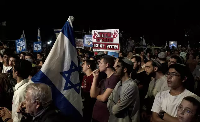 Right-wing Israelis with relatives held hostage by Hamas in the Gaza Strip, and their supporters, rally against a hostage deal, in Jerusalem, Thursday, Sept. 19, 2024. The placard in Hebrew reads: " To bathe in his blood." (AP Photo/Maya Alleruzzo)