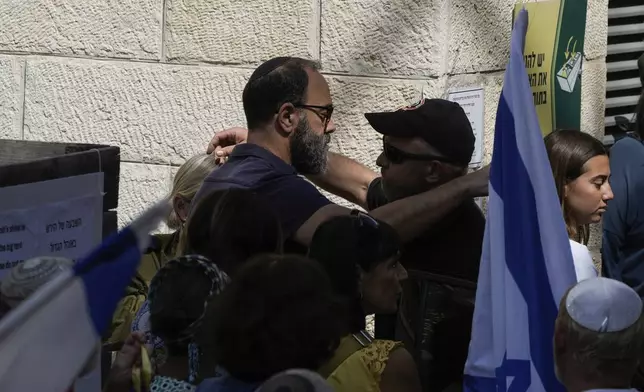 A mourner comforts Jon Polin, left, father of Israeli-American hostage Hersh Goldberg-Polin, who was killed in Hamas captivity in the Gaza Strip, on his way to his son's funeral in Jerusalem, Monday, Sept. 2, 2024. Israel said Sunday it recovered the bodies of six hostages, including Goldberg-Polin's. (AP Photo/Leo Correa)