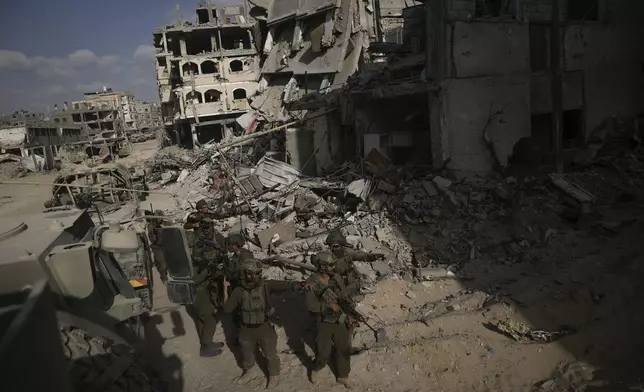 Israeli soldiers take up position next to destroyed buildings following Israeli strikes during a ground operation in the Gaza Strip on Friday, Sept. 13, 2024. (AP Photo/Leo Correa)