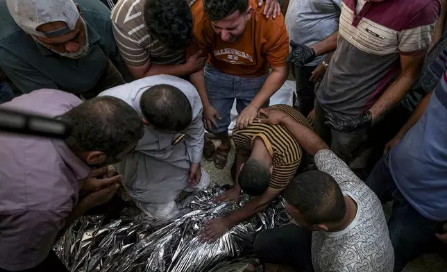 Palestinians mourn a relative killed in the Israeli bombardment of the Gaza Strip at a hospital morgue in Deir al-Balah, Sunday, Sept. 1, 2024. (AP Photo/Abdel Kareem Hana)