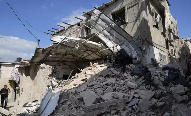 A Palestinian refugee saves some belongings from his families house that was destroyed during the Israeli army operation in the West Bank refugee camp of Tulkarem, in Tulkarem, Thursday, Sept. 5, 2024. (AP Photo/Nasser Nasser)