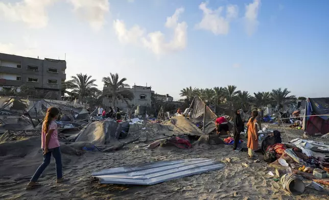 Palestinians look at the destruction after an Israeli airstrike on a crowded tent camp housing Palestinians displaced by the war in Muwasi, Gaza Strip, Tuesday, Sept. 10, 2024. An Israeli strike killed at least 40 people and wounded 60 others early Tuesday, Palestinian officials said. Israel said it targeted "significant" Hamas militants, allegations denied by the militant group. (AP Photo/Abdel Kareem Hana)