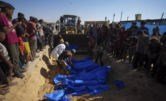 People bury the bodies of Palestinians taken by the Israeli military during operations in Gaza and returned this week, in Khan Younis, Gaza Strip, Thursday, Sept. 26, 2024. (AP Photo/Abdel Kareem Hana)