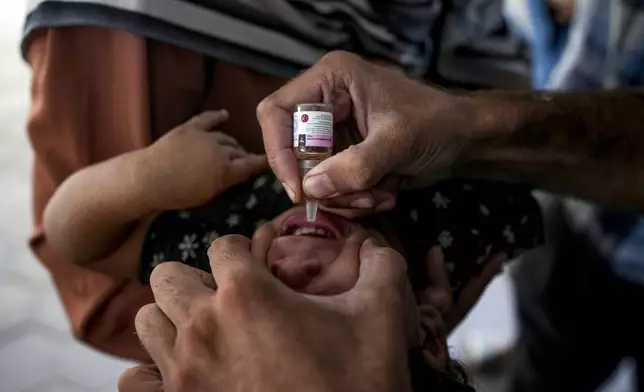 A health worker administers a polio vaccine to a child at a hospital in Deir al-Balah, central Gaza Strip, Sunday, Sept. 1, 2024. (AP Photo/Abdel Kareem Hana)