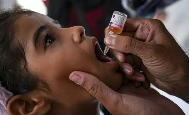 A health worker administers a polio vaccine to a child at a hospital in Deir al-Balah, central Gaza Strip, Sunday, Sept. 1, 2024. (AP Photo/Abdel Kareem Hana)