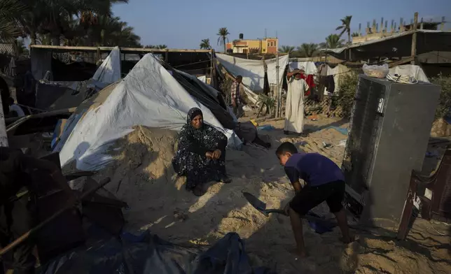 Palestinians look at the destruction after an Israeli airstrike on a crowded tent camp housing Palestinians displaced by the war in Muwasi, Gaza Strip, Tuesday, Sept. 10, 2024. An Israeli strike killed at least 40 people and wounded 60 others early Tuesday, Palestinian officials said. Israel said it targeted "significant" Hamas militants, allegations denied by the militant group. (AP Photo/Abdel Kareem Hana)