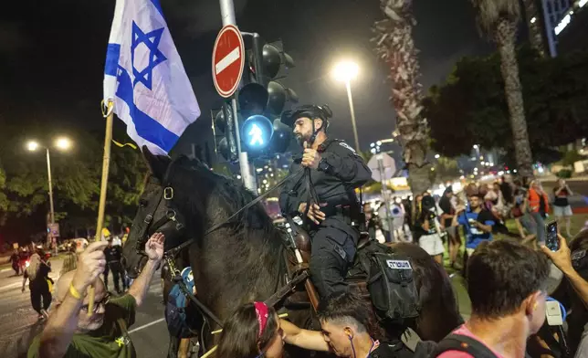 People protest against Prime Minister Benjamin Netanyahu's government and call for the release of hostages held in the Gaza Strip by the Hamas militant group, in Tel Aviv, Israel, Saturday, Aug. 31, 2024. (AP Photo/Ohad Zwigenberg)