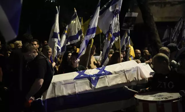 People carry mock coffins covered with the Israeli flag during a rally demanding a cease-fire deal and the immediate release of hostages held by Hamas in the Gaza Strip after the deaths of six hostages in the Palestinian territory , in Jerusalem, on Monday, Sept. 2, 2024. (AP Photo/Leo Correa)