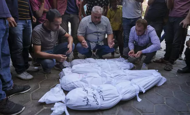 Palestinians mourn their relatives, including kids killed in the Israeli bombardment of the Gaza Strip, outside a morgue in Deir al-Balah, Gaza, Monday, Sept. 23, 2024. (AP Photo/Abdel Kareem Hana)