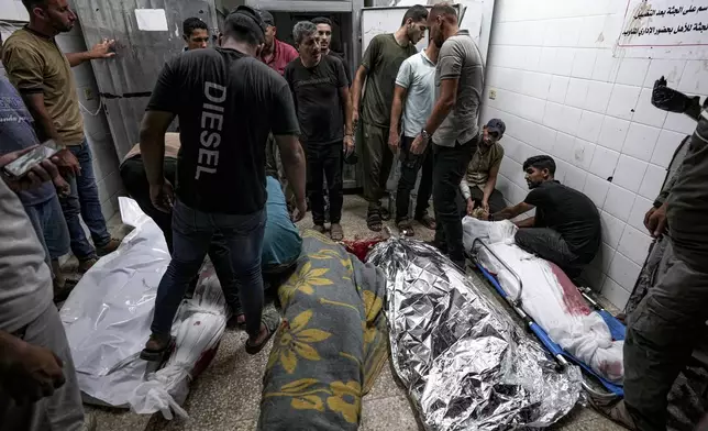 Palestinians check the bodies of their relatives killed in the Israeli bombardment of the Gaza Strip, at a hospital morgue in Deir al-Balah, Sunday, Sept. 1, 2024. (AP Photo/Abdel Kareem Hana)