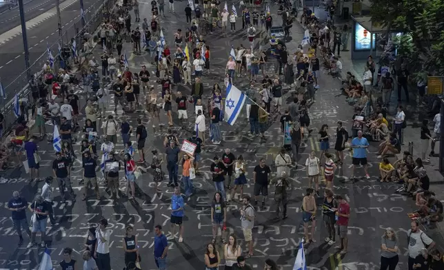 People protest against Prime Minister Benjamin Netanyahu's government and call for the release of hostages held in the Gaza Strip by the Hamas militant group, in Tel Aviv, Israel, Saturday, Aug. 31, 2024. (AP Photo/Ohad Zwigenberg)