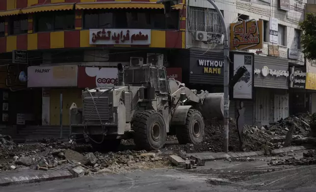 An Israeli bulldozer moves on a damaged street during a military operation in the West Bank city of Jenin, Sunday, Sept. 1, 2024. (AP Photo/Majdi Mohammed)