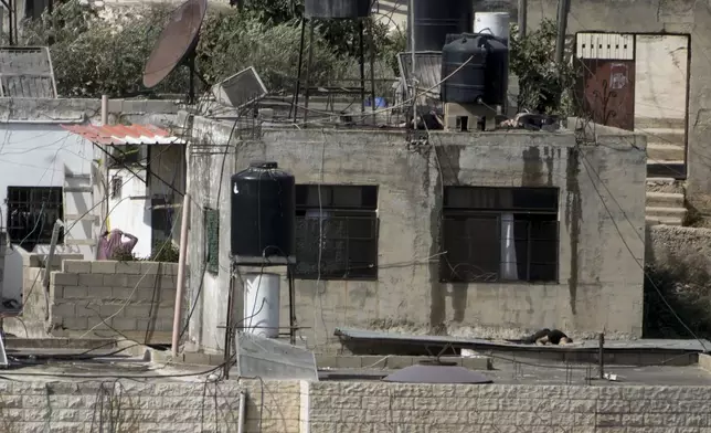 EDS NOTE: GRAPHIC CONTENT - Three bodies lie motionless on rooftops in the West Bank town of Qatabiya during a Israeli raid, Thursday, Sept. 19, 2024. (AP Photo/Majdi Mohammed)