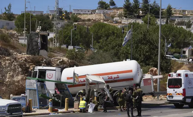 Israeli security forces inspect the scene of what they say is a Palestinian ramming attack at a bus station near the West Bank Jewish settlement of Beit El, Wednesday, Sept. 11, 2024. (AP Photo/Ohad Zwigenberg)