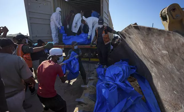 People bury the bodies of Palestinians taken by the Israeli military during operations in Gaza and returned this week, in Khan Younis, Gaza Strip, Thursday, Sept. 26, 2024. (AP Photo/Abdel Kareem Hana)