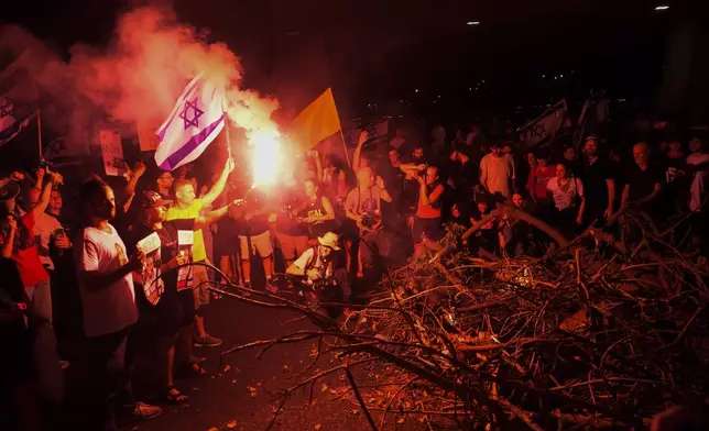 People block a road as they protest calling for a deal for immediate release of hostages held in the Gaza Strip by the Hamas militant group, in Tel Aviv, Sunday, Sept. 1, 2024. (AP Photo/Ariel Schalit)