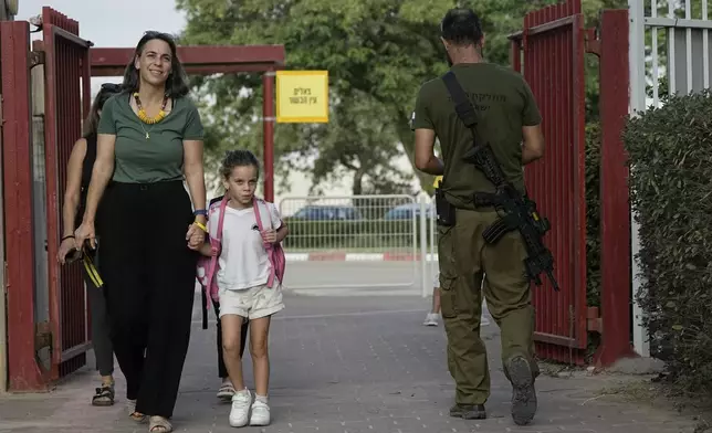 Students arrive at their elementary school on the first day of classes near the kibbutz Magen, located on an area near the border with Gaza Strip, southern Israel, Sunday, Sept. 1, 2024. (AP Photo/Tsafrir Abayov)