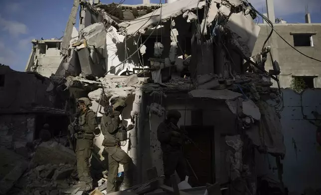 Israeli soldiers take up position next to destroyed buildings following Israeli strikes during a ground operation in the Gaza Strip on Friday, Sept. 13, 2024. (AP Photo/Leo Correa)