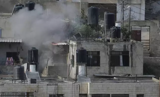 EDS NOTE: GRAPHIC CONTENT - An explosion is seen as three bodies lie motionless on rooftops in the West Bank town of Qabatiya during a raid, Thursday, Sept. 19, 2024. (AP Photo/Majdi Mohammed)