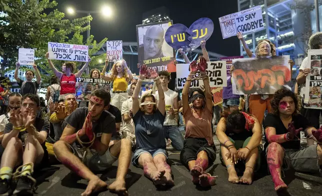 Blindfolded and bounded protesters take part in a protest against Israeli Prime Minister Benjamin Netanyahu's government and call for the release of hostages held in the Gaza Strip by the Hamas militant group in Tel Aviv, Israel, Tuesday, Sept. 10, 2024. (AP Photo/Ohad Zwigenberg)