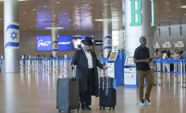 Travelers line up at Ben Gurion International Airport near Tel Aviv, Israel, Monday Sept. 2, 2024. Outgoing flights at the airport were halted for two hours on Monday morning as part of a general strike launched in response to the deaths of hostages held in Gaza. (AP Photo/Ohad Zwigenberg)