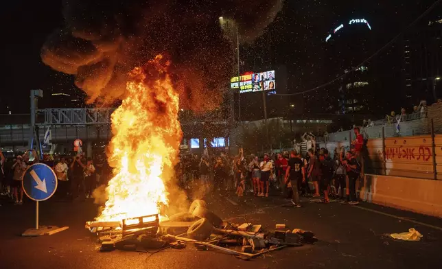 People block a road as they protest, calling for a deal for the immediate release of hostages held in the Gaza Strip by Hamas, in Tel Aviv, Israel, Sunday, Sept. 1, 2024. (AP Photo/Ohad Zwigenberg)