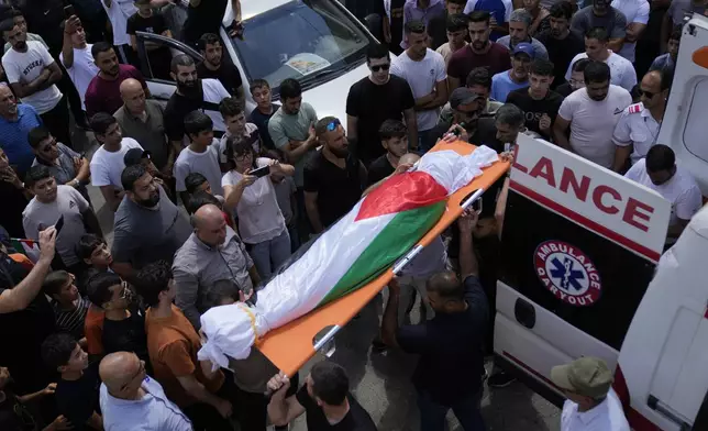 Mourners carry the body of Palestinian girl Bana Bakr, 13, into the family house during her funeral in the West Bank village of Qaryut, south of Nablus, Saturday, Sept. 7, 2024. Bakr was killed by Israeli fire, the Palestinian health ministry said. The Israeli army said they were reviewing the incident. (AP Photo/Nasser Nasser)