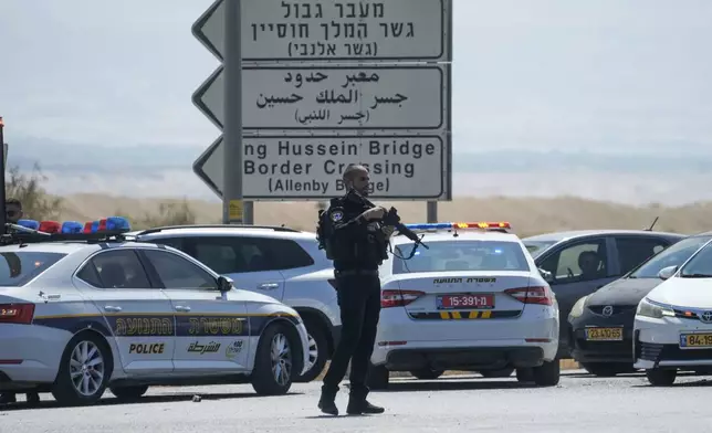 Israeli police stand guard near the site of a deadly shooting attack where Israeli officials say three people were shot and killed at the Allenby Bridge Crossing between the West Bank and Jordan, Sunday, Sept. 8, 2024. (AP Photo/Mahmoud Illean)