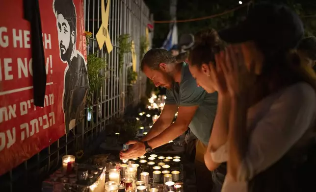 People light candles during a vigil in memory of slain hostage Hersh Goldberg-Polin in Jerusalem, Israel, Sunday, Sept. 1, 2024. (AP Photo/Leo Correa)