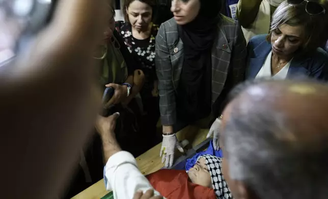 Palestinians look at the body of Turkish-American Aysenur Ezgi Eygi at the hospital morgue in Nablus, West Bank, Sunday, Sept. 8, 2024. Eygi, 26, died after being shot in the head on Friday, Palestinian doctors said. Witnesses to the shooting said the was fatally shot by Israeli forces in a moment of calm after clashes between Palestinians and Israeli forces in the northern West Bank. (AP Photo/Majdi Mohammed)