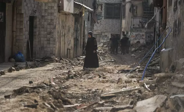 Palestinians walk on a damaged road following an Israeli military operation in the West Bank city of Jenin on Friday, Sept. 6, 2024. (AP Photo/Majdi Mohammed)