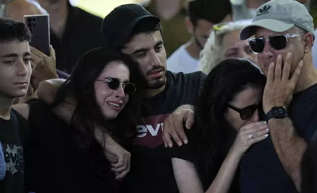 Relatives and friends mourn during the funeral of slain hostage Almog Sarusi, who was killed in Hamas captivity in the Gaza Strip, at a cemetery in Ra'anana, Israel, Sunday, Sept. 1, 2024. (AP Photo/Ariel Schalit)